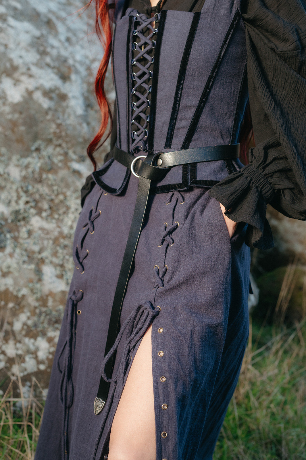 Close-up of a model wearing the Navy Tavern Bodice with laced front and black belt over a black blouse outdoors