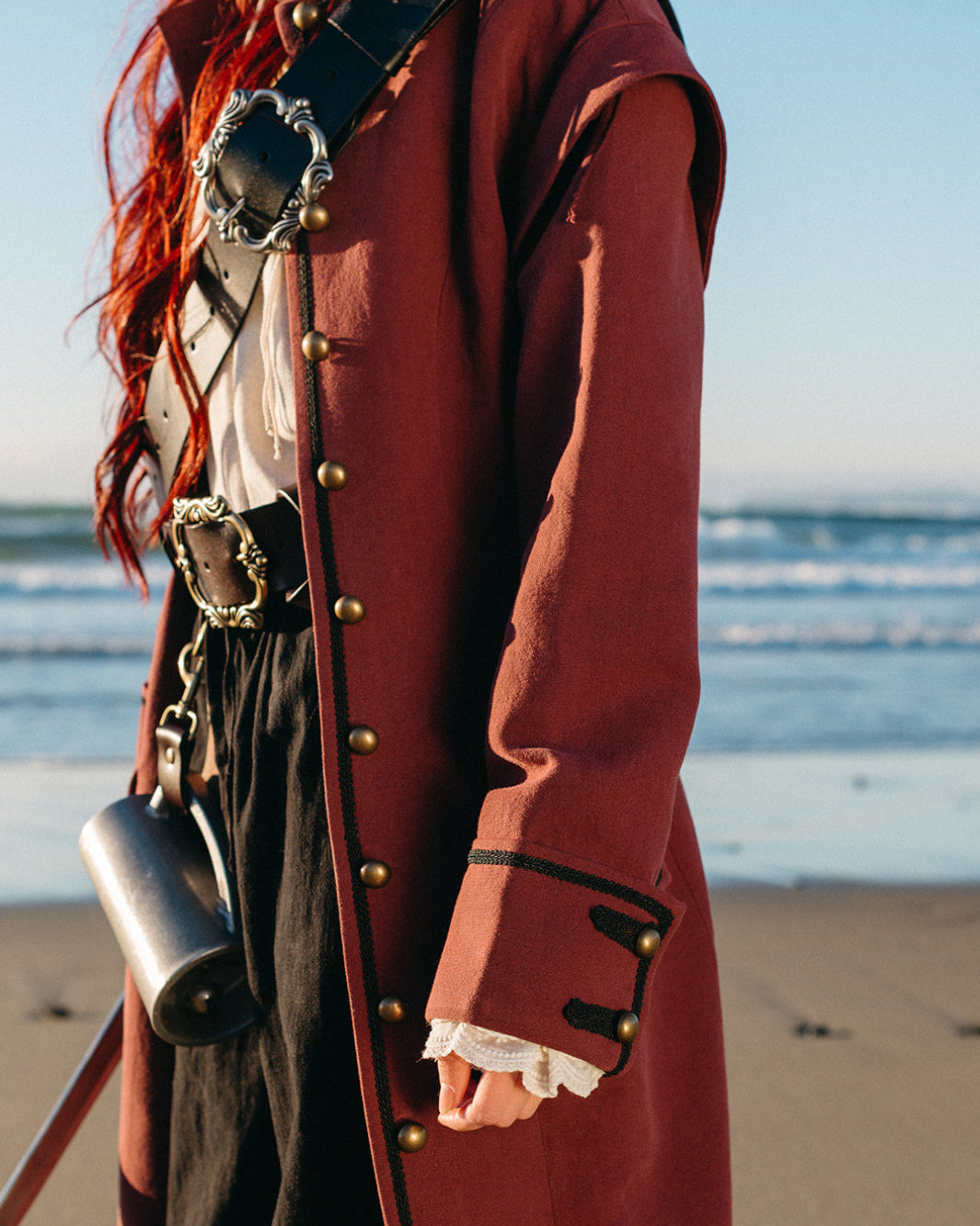 Lacey Ruffle Sleeves adding delicate flounce detail to a vintage-inspired coat cuff by the ocean shore