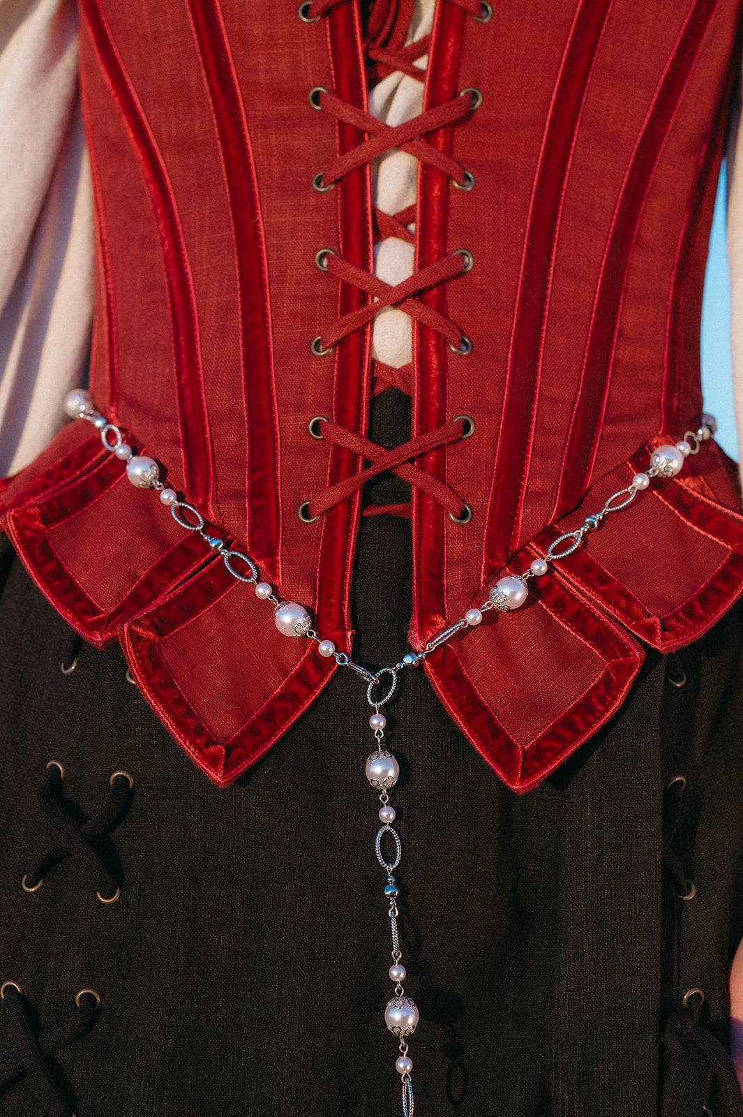Pearl Medieval Chain Belt worn over red corset with imitation pearls and ornate metal flower details.
