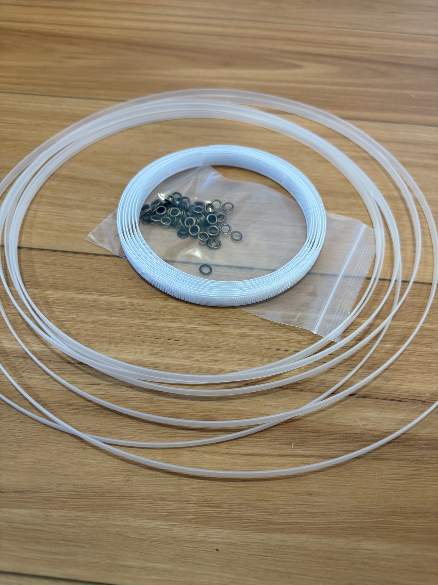 Corset Making Materials Kit showing plastic boning, rigiline, and bronze grommets.