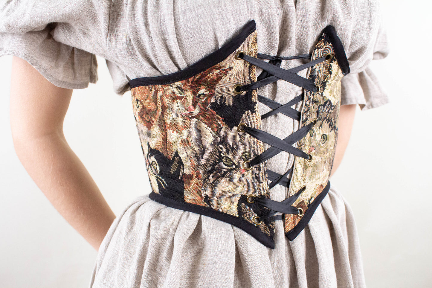 Corset Belt PDF Sewing Pattern showing a handmade corset belt with cat tapestry and front lacing on a beige dress