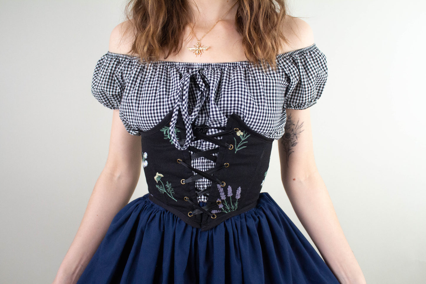 Woman wearing a black floral corset belt with front lacing made using the Corset Belt PDF Sewing Pattern