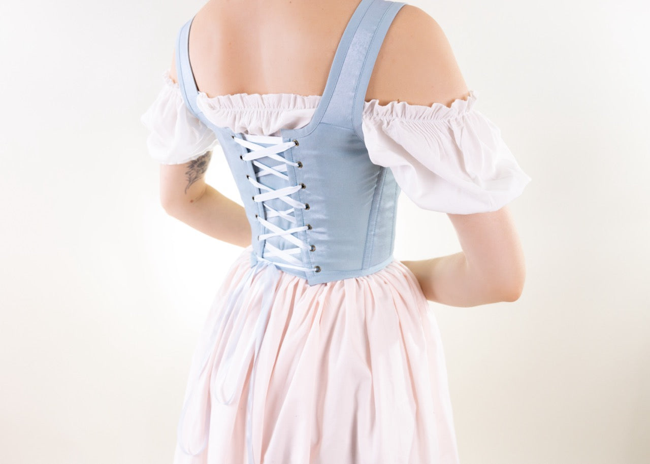 Woman wearing Handmade Light Blue and Pink Elizabethan Stays corset with lace-up back and puffed sleeves from behind