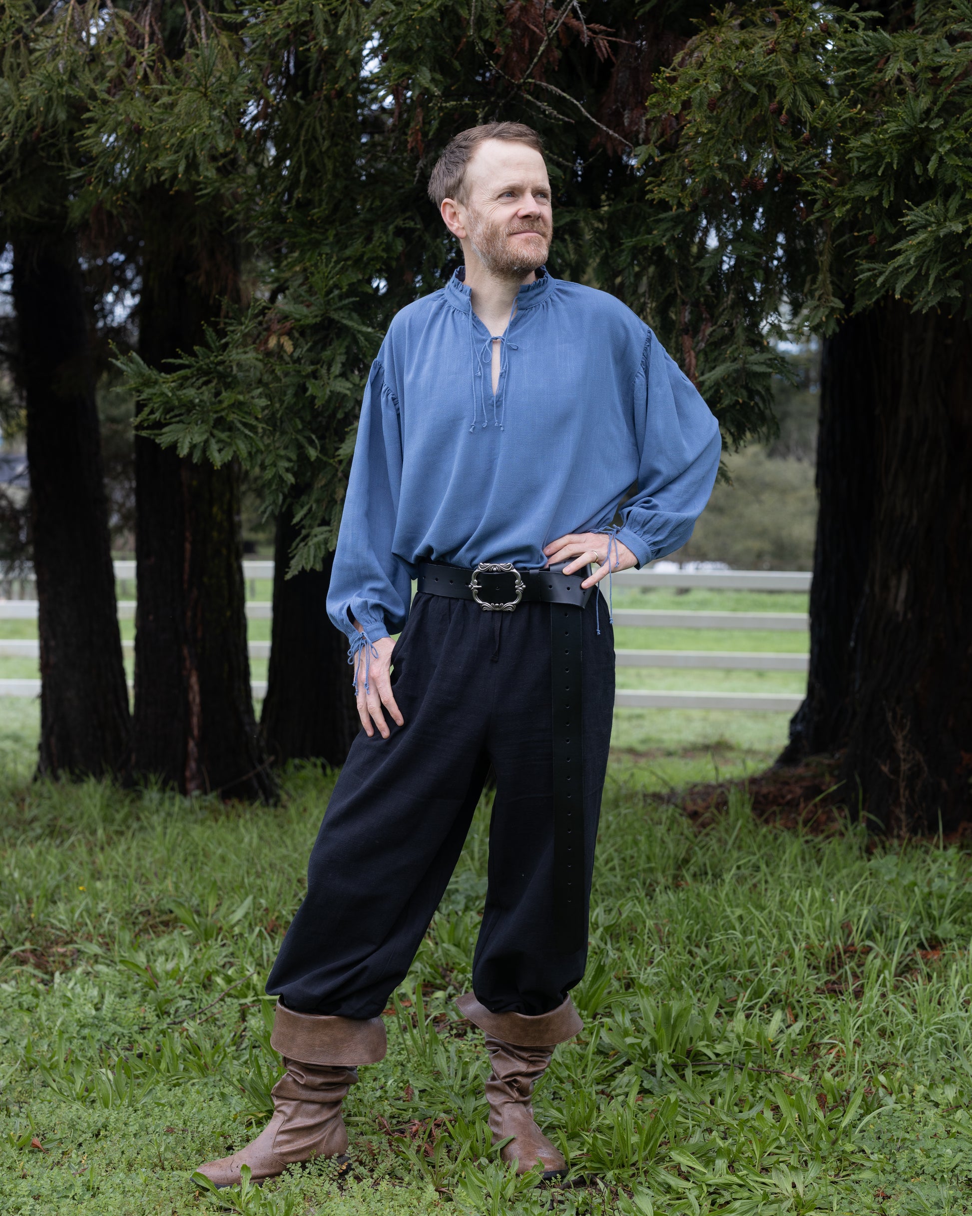 Man wearing a blue Borgia Shirt inspired by Italian Renaissance standing outdoors with hands on hips