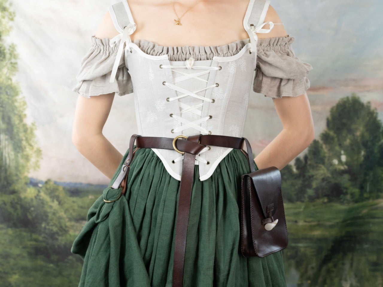 Woman wearing a Handmade Beige Fern Corset with laced front, paired with off-shoulder top and green skirt outdoors