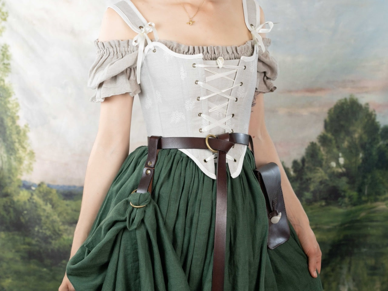 Woman wearing a Handmade Beige Fern Corset with off-shoulder beige blouse and green skirt in outdoor setting