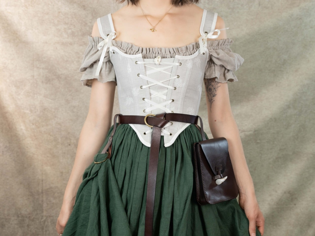 Woman wearing Handmade Beige Fern Corset over off-shoulder blouse with green skirt and brown leather belt pouch