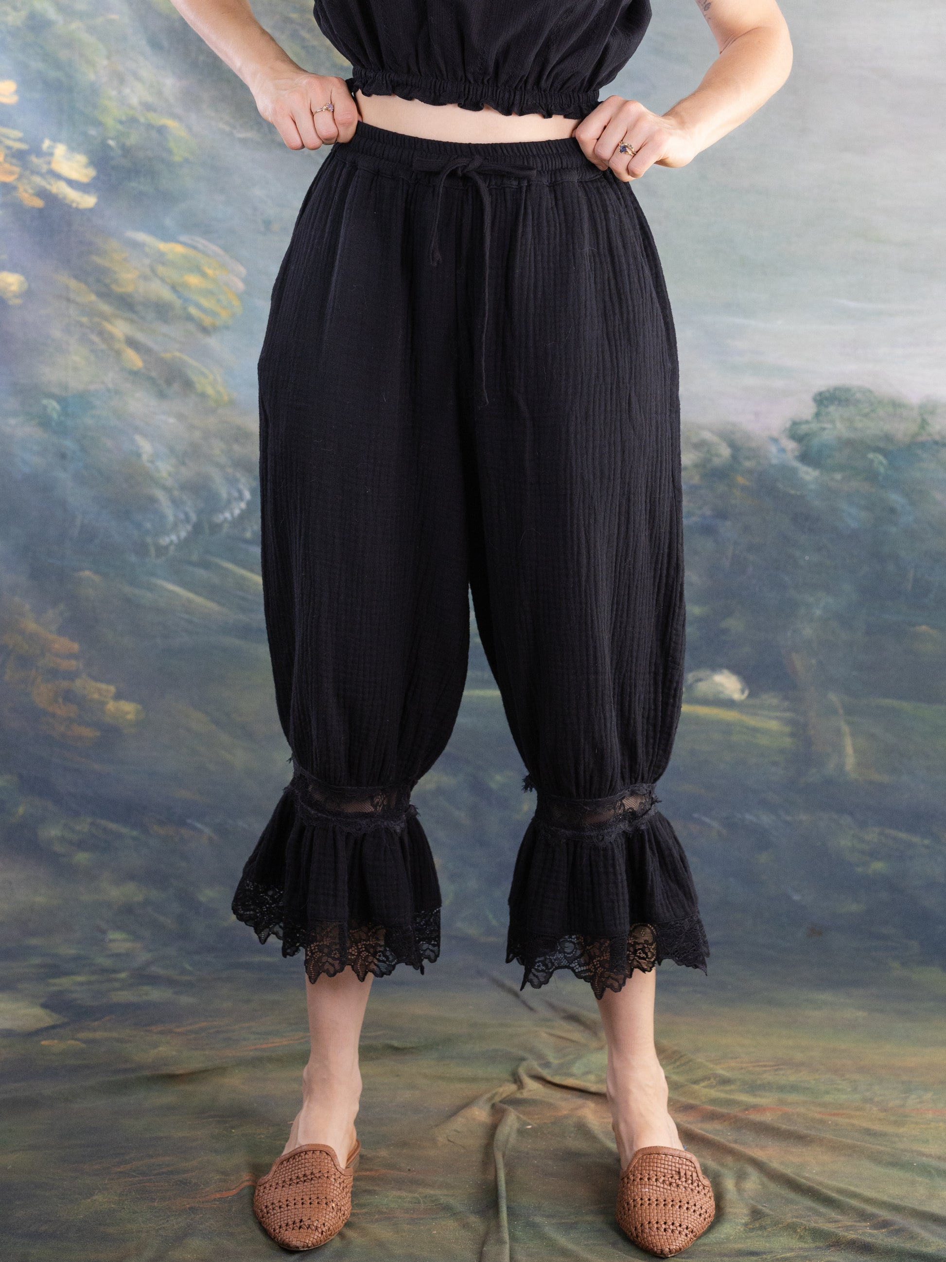 Black Bloomer Pantaloons with lace trim at cropped hems worn by model against artistic backdrop