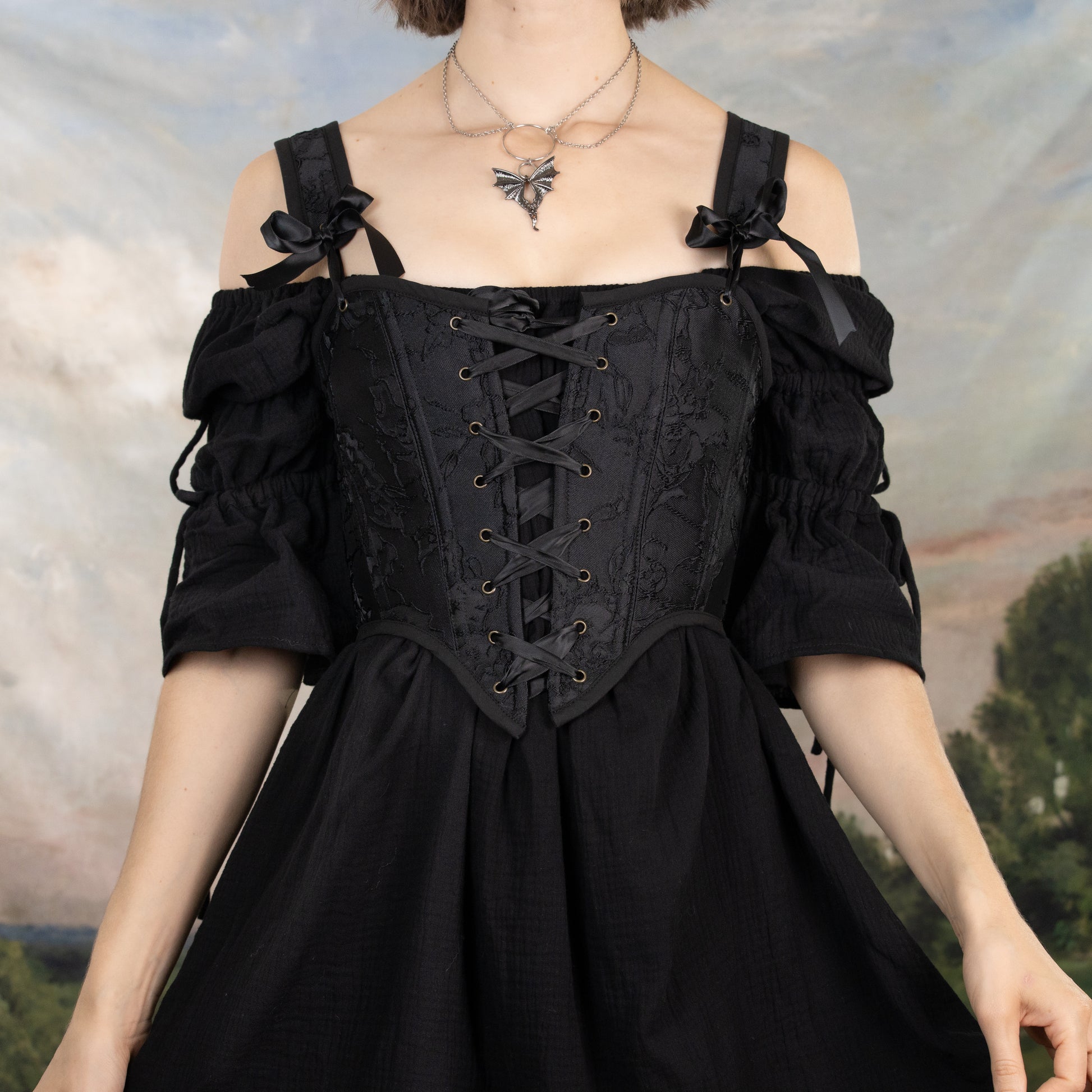 model wearing a black corset with a floral jacquard design woven into the fabric