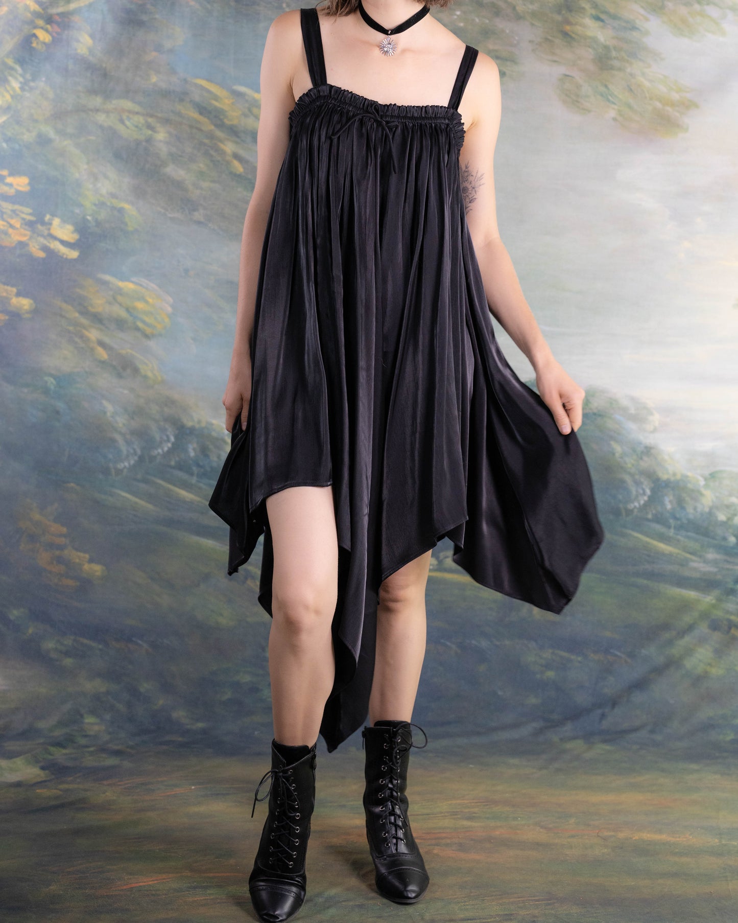 Black Flutter Fairy Dress shown on model with handkerchief hem and flowing satin fabric in a whimsical style