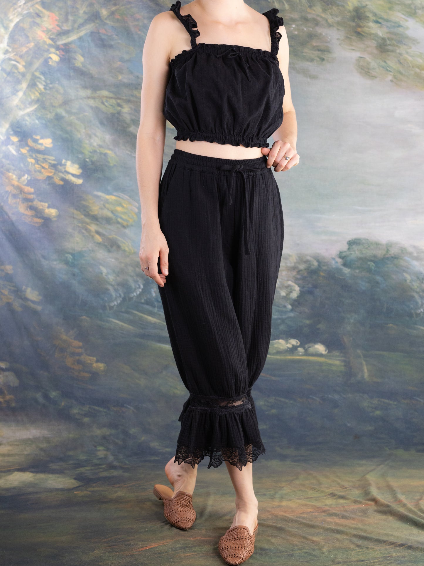 Model wearing Lacey Chemisette Tank black cropped top with ruffled straps and elastic hem for layering or standalone style