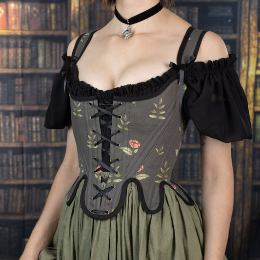 Woman wearing Handmade Black Rose Floral 18th Century Stays corset with black lace and floral embroidery over green skirt