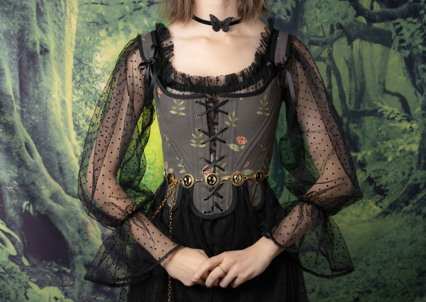 A model wearing Handmade Black Rose Floral 18th Century Stays with sheer black sleeves and a butterfly choker.