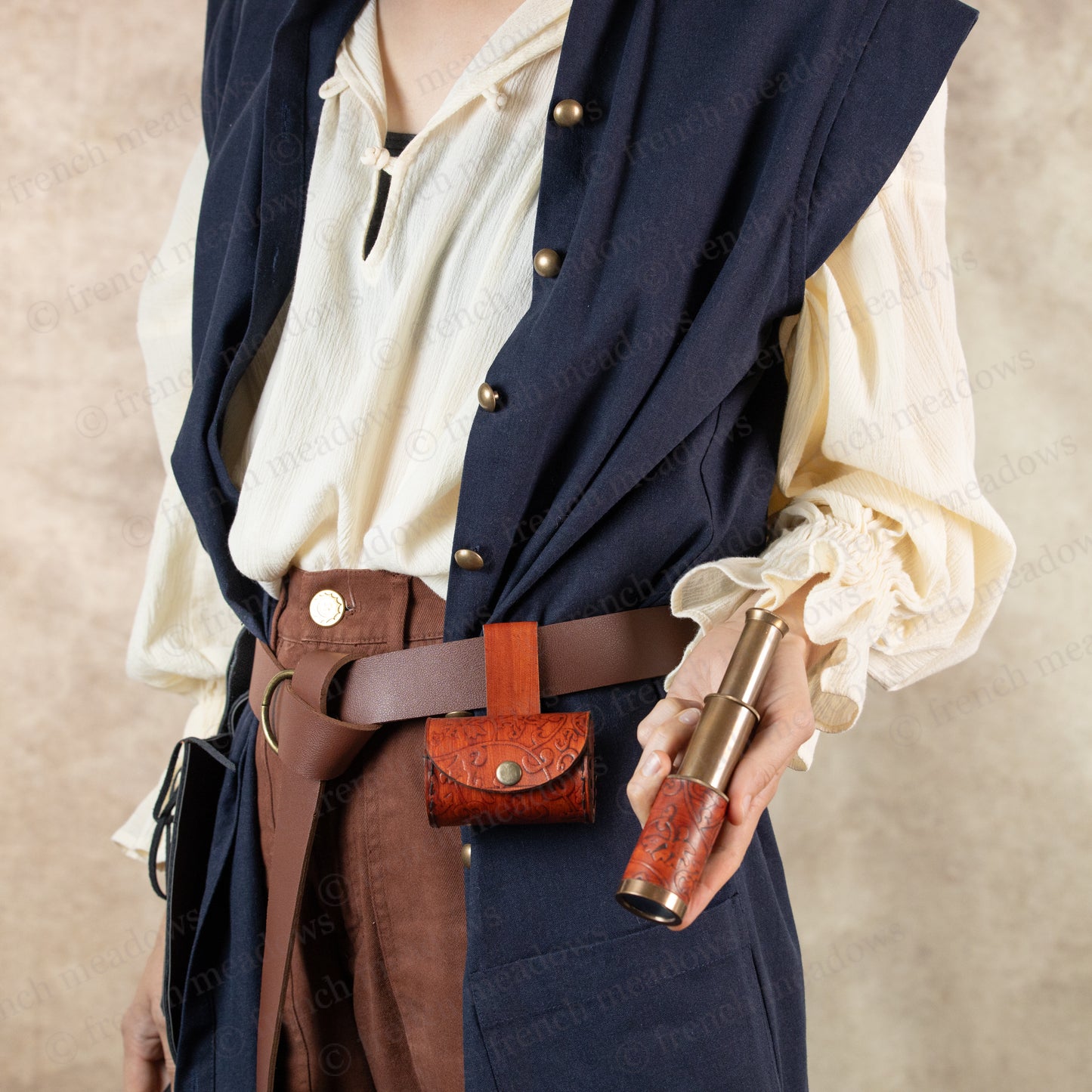 model dressed in pirate costume holding telescope in hand