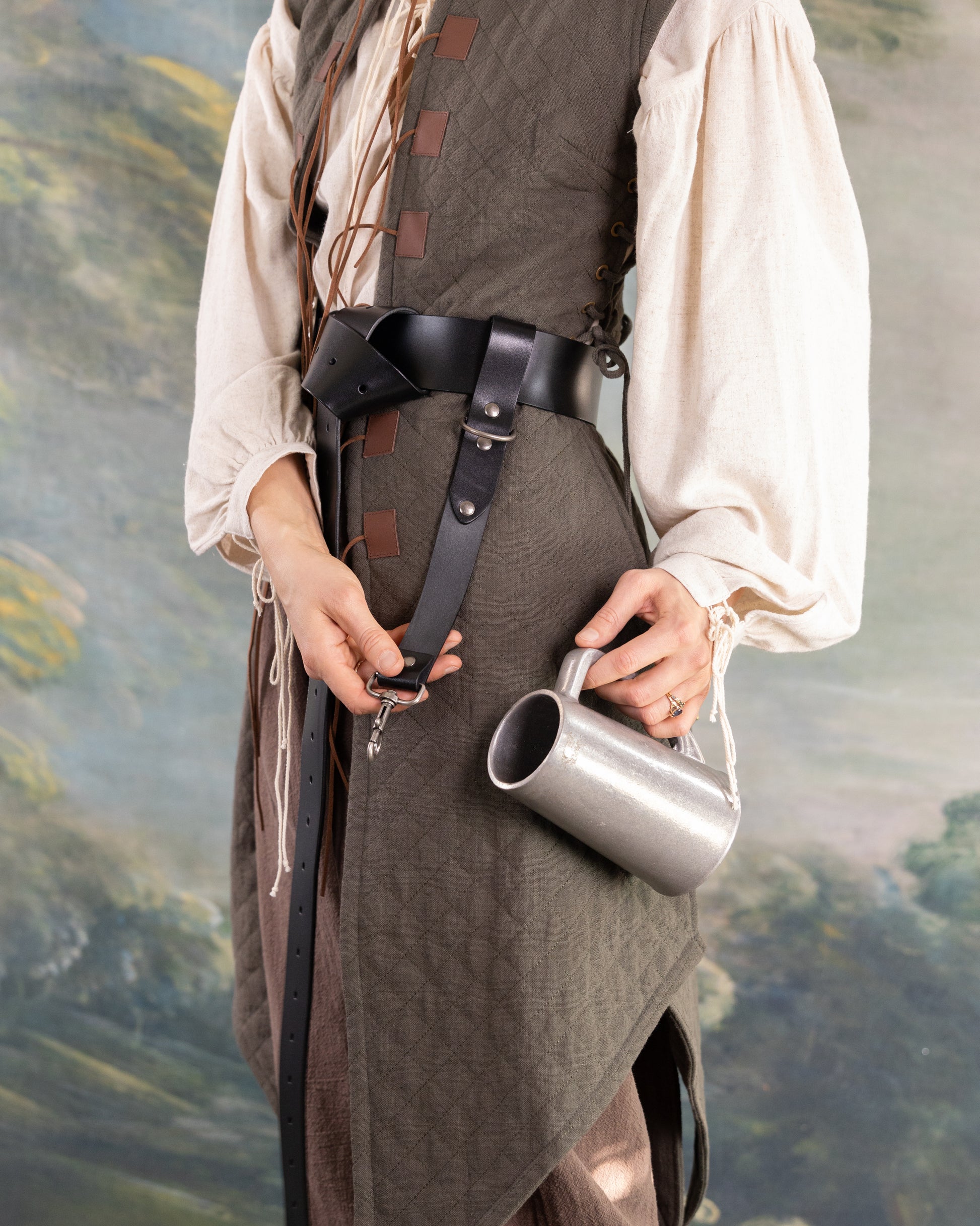 Person wearing medieval costume with Heavy Duty Leather Tankard Strap holding metal mug by its handle