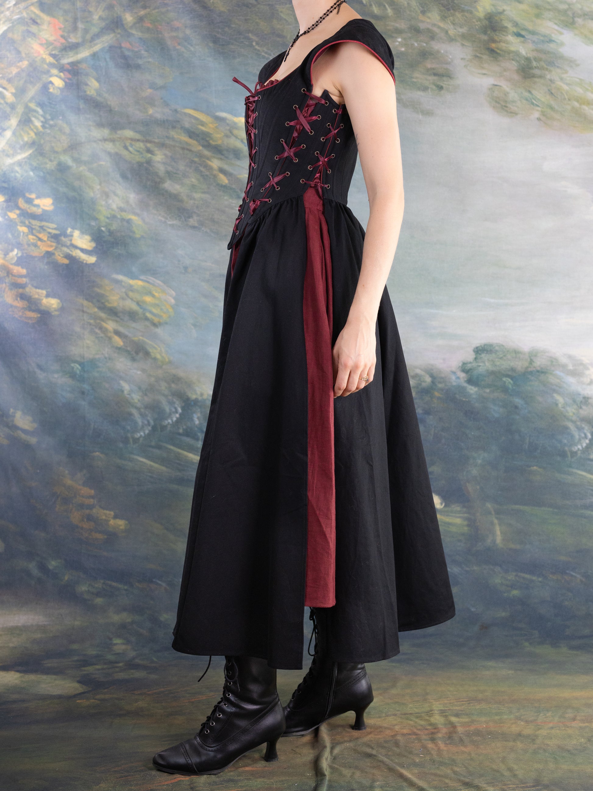 Side view of a model wearing the Black Vampire Slayer Corset Dress with laced bodice and flowing skirt