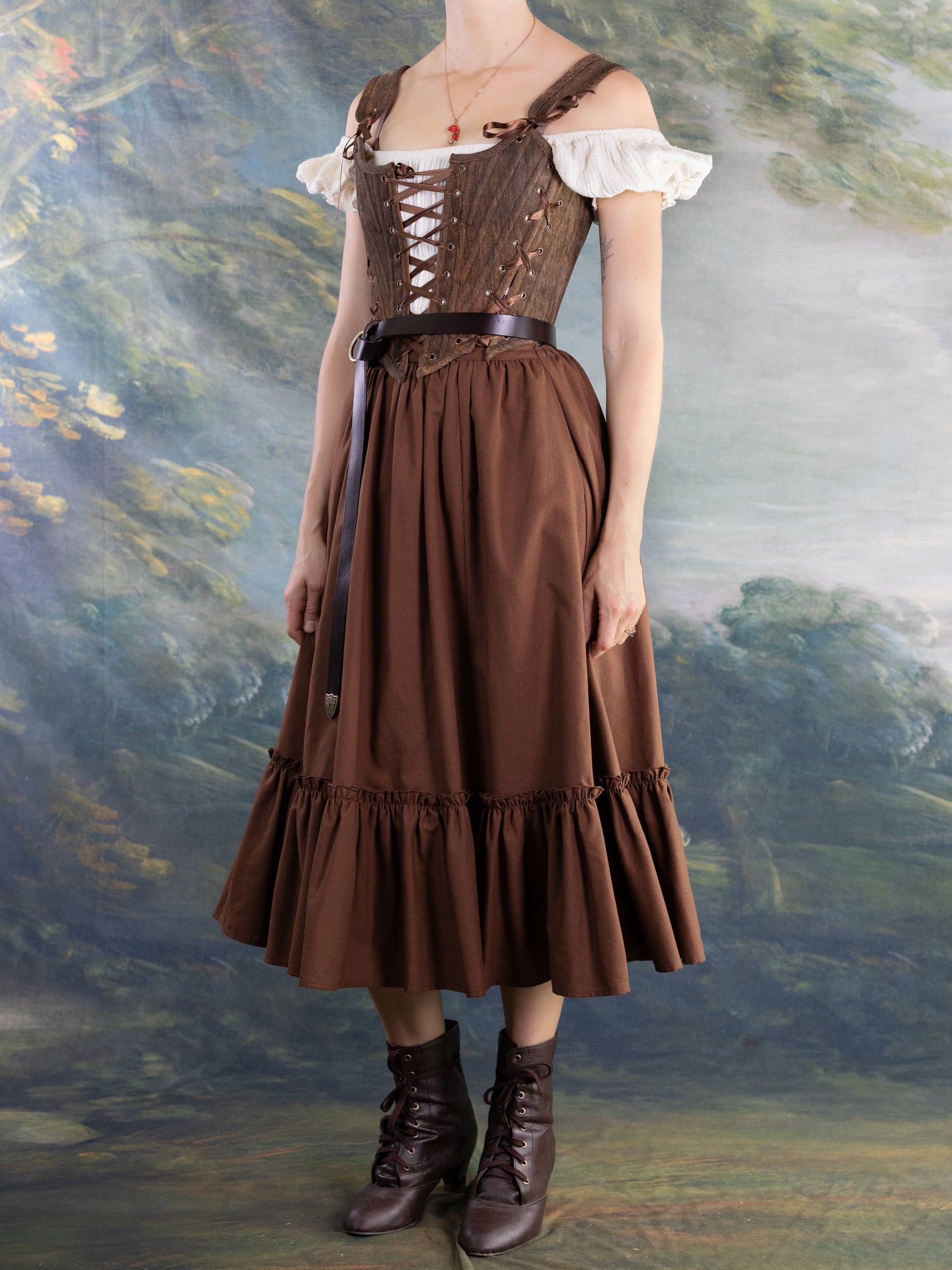 Woman wearing a vintage style brown dress and lace-up Brown Princess Stays corset with a belt and boots