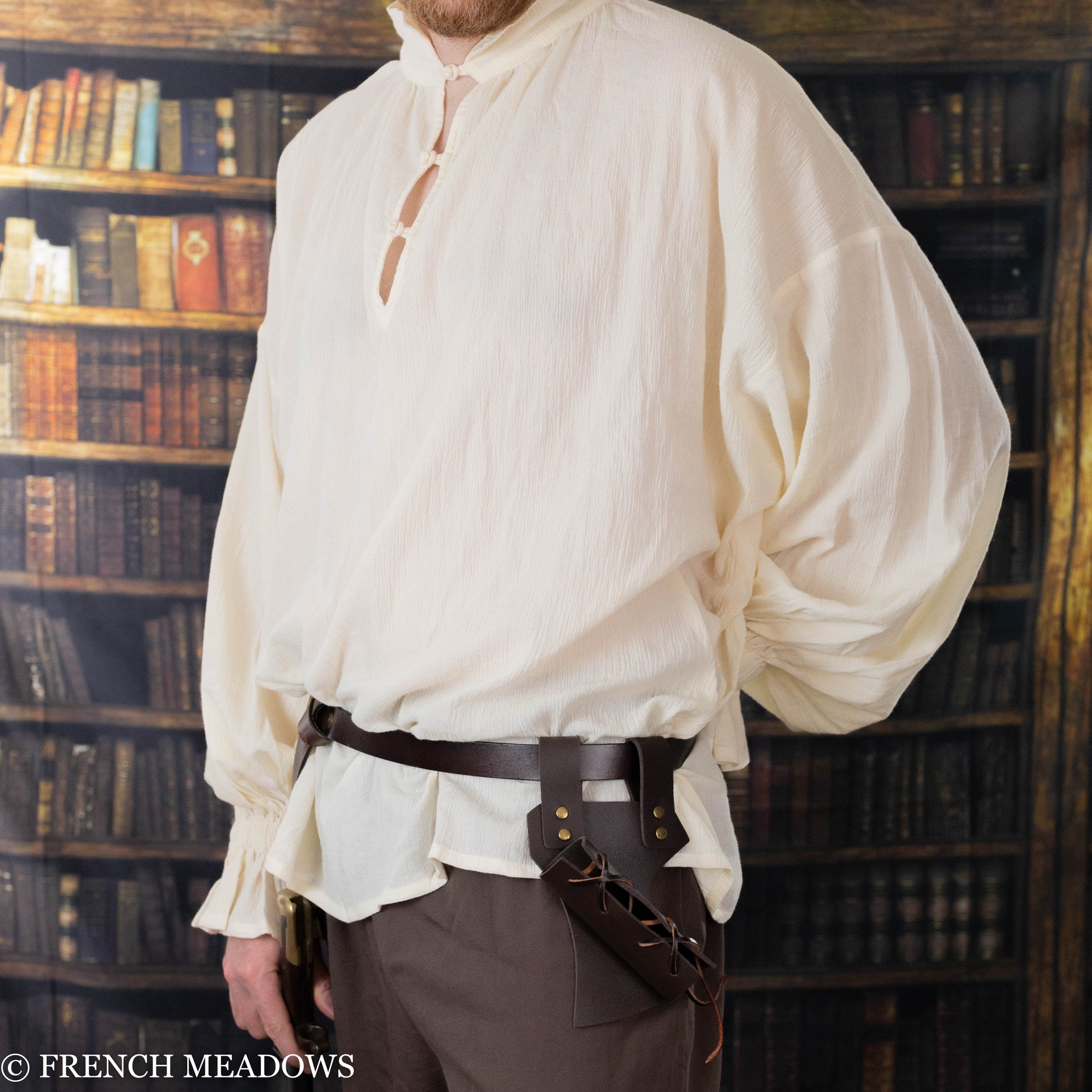 male model wearing a mens renaissance faire costume consisting of a long ivory tunic and belt