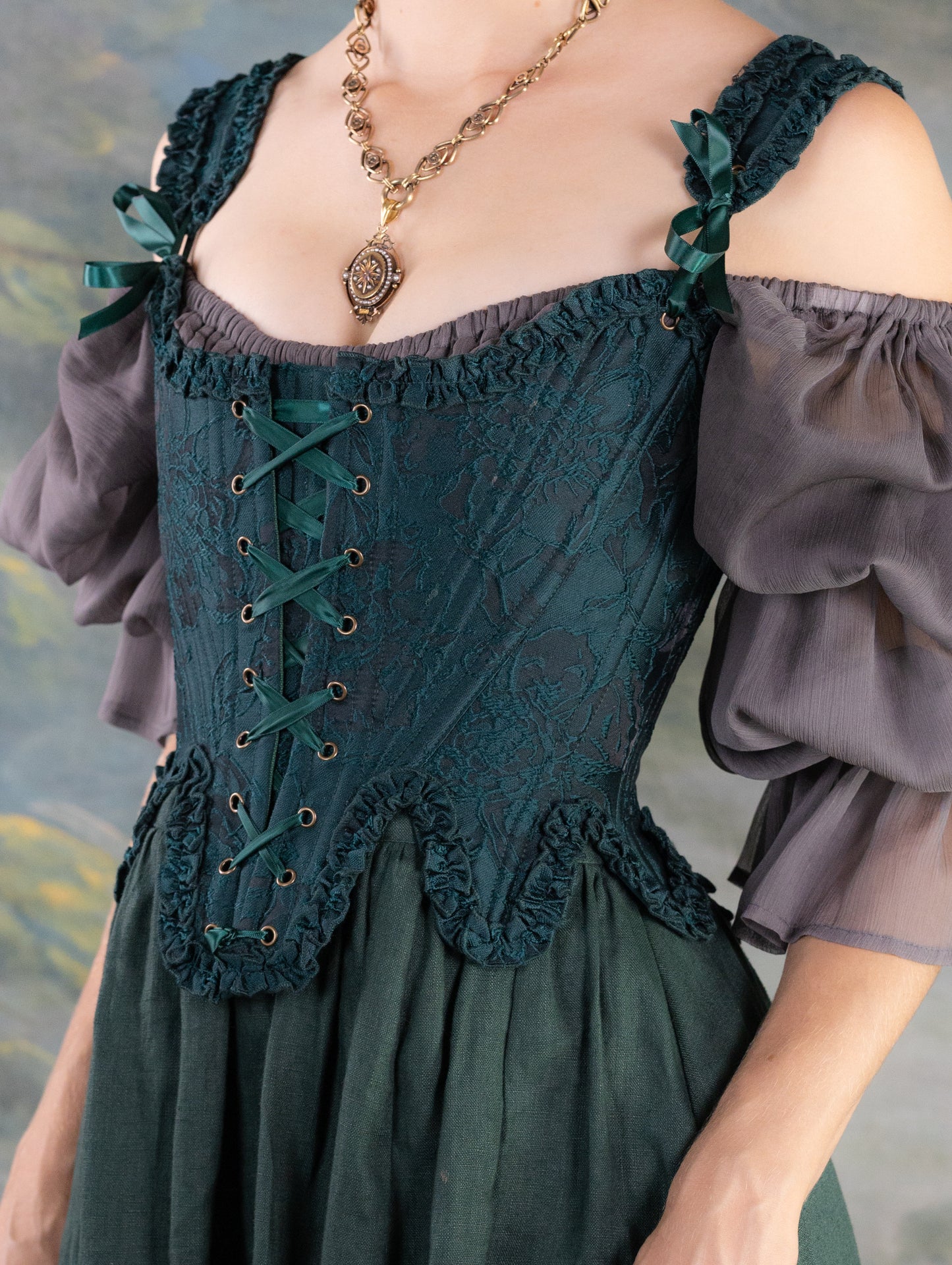 Dark Green Floral Jacquard 18th Century Stays with ruffled neckline and waistline, laced front, styled with sheer sleeves and pendant necklace