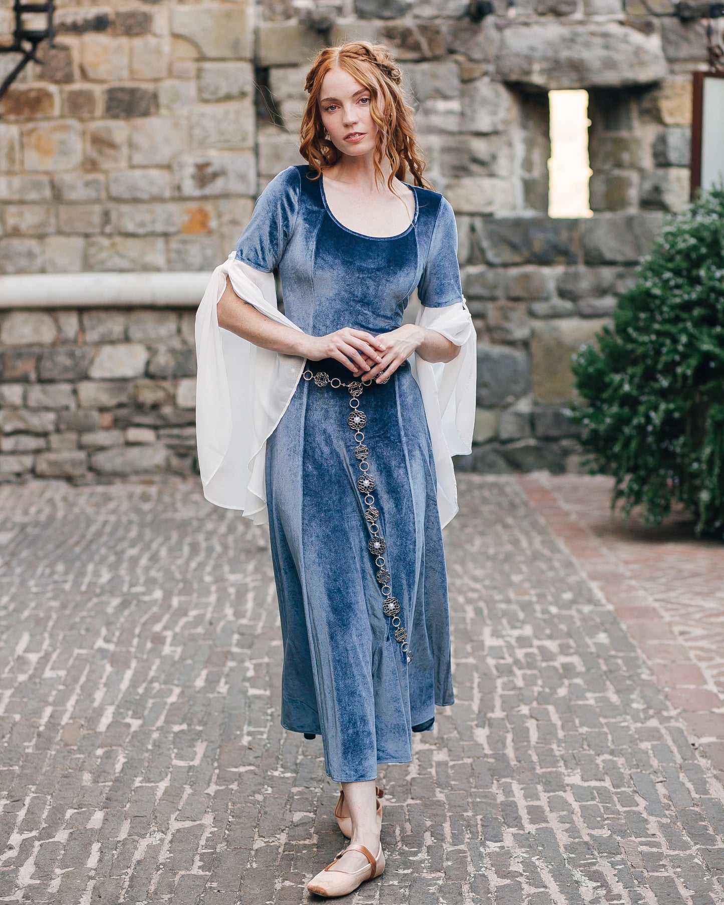 Rosette Medieval Chain Belt styled over a flowing medieval-inspired blue velvet dress with filigree rosette medallions detail