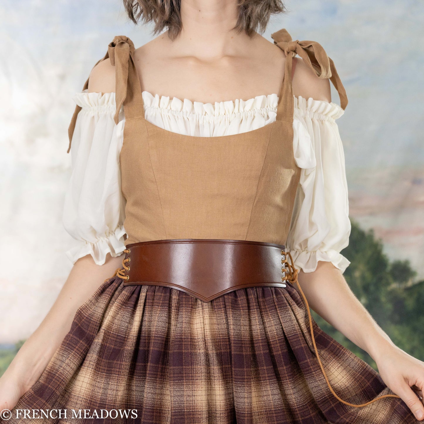 model wearing a renaissance faire costume with an unboned corset