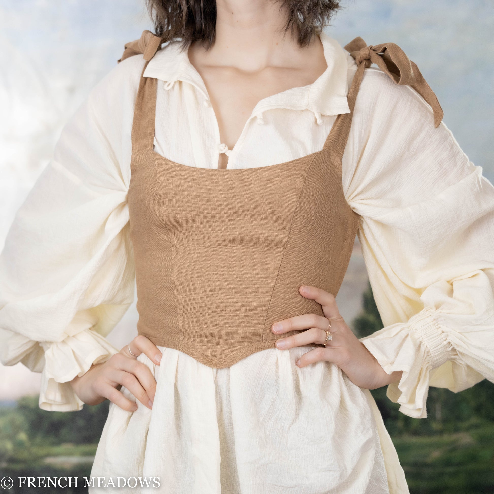 model wearing light brown fitted top over a medieval tunic