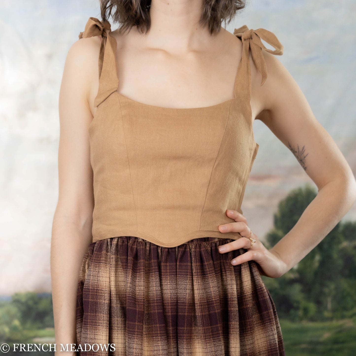 female model wearing a brown corset top with a brown plaid skirt