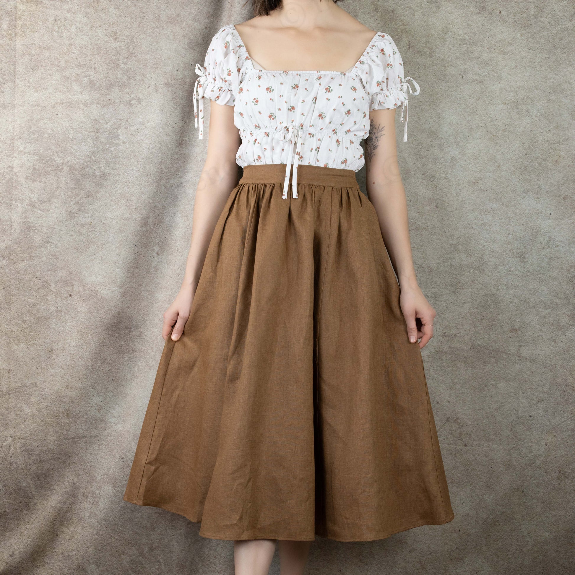 front view of model wearing ginger brown midi skirt with white floral dress