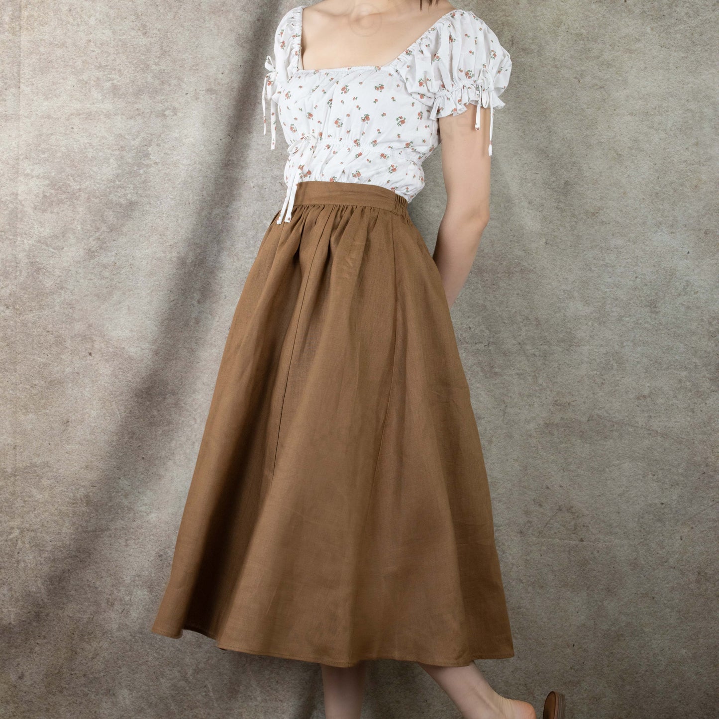 model wearing brown linen skirt over milkmaid dress