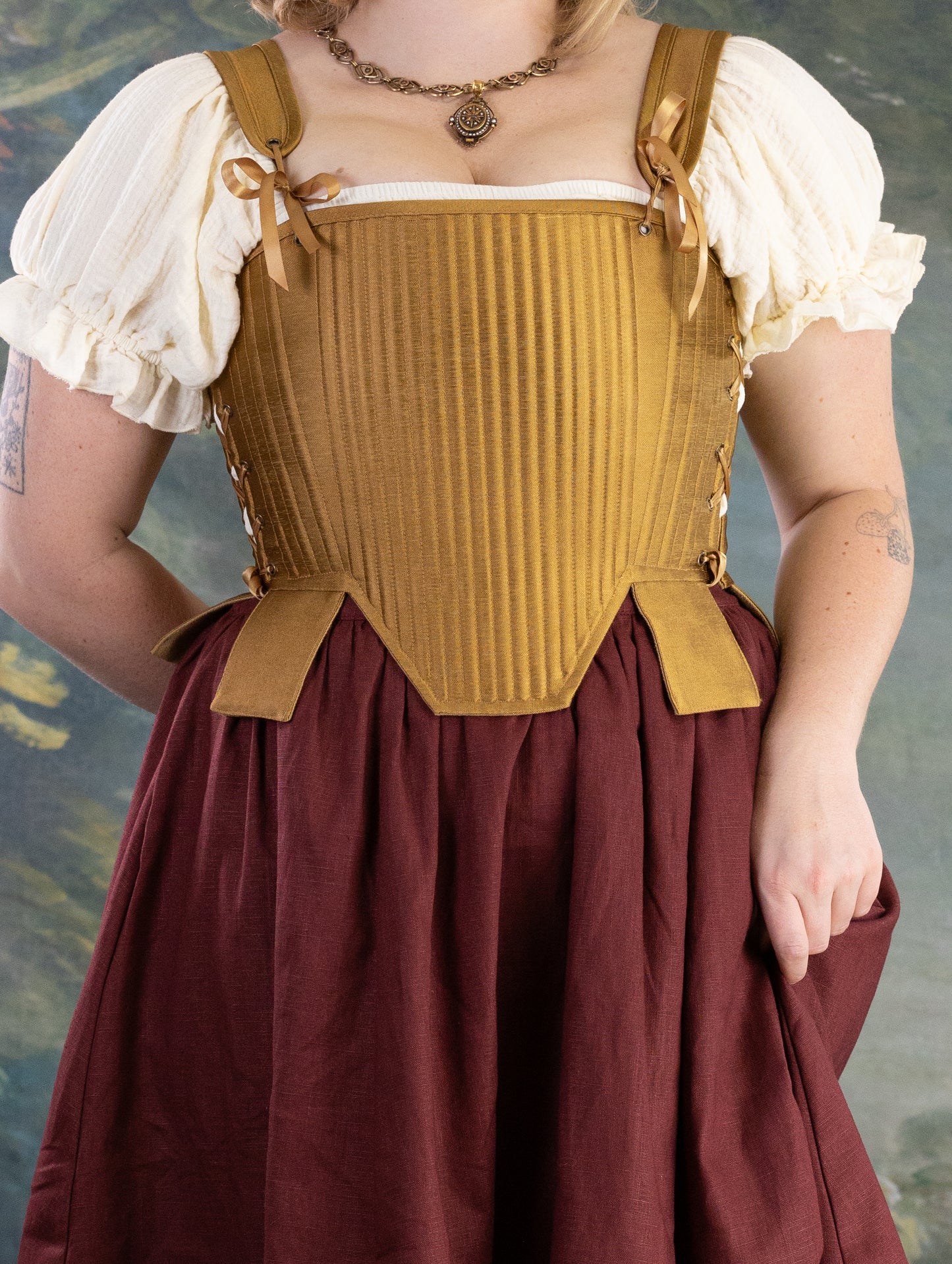 Gold Tabbed Tudor Stays with adjustable lacing and decorative waist tabs in a rich golden tone on a vintage-inspired outfit