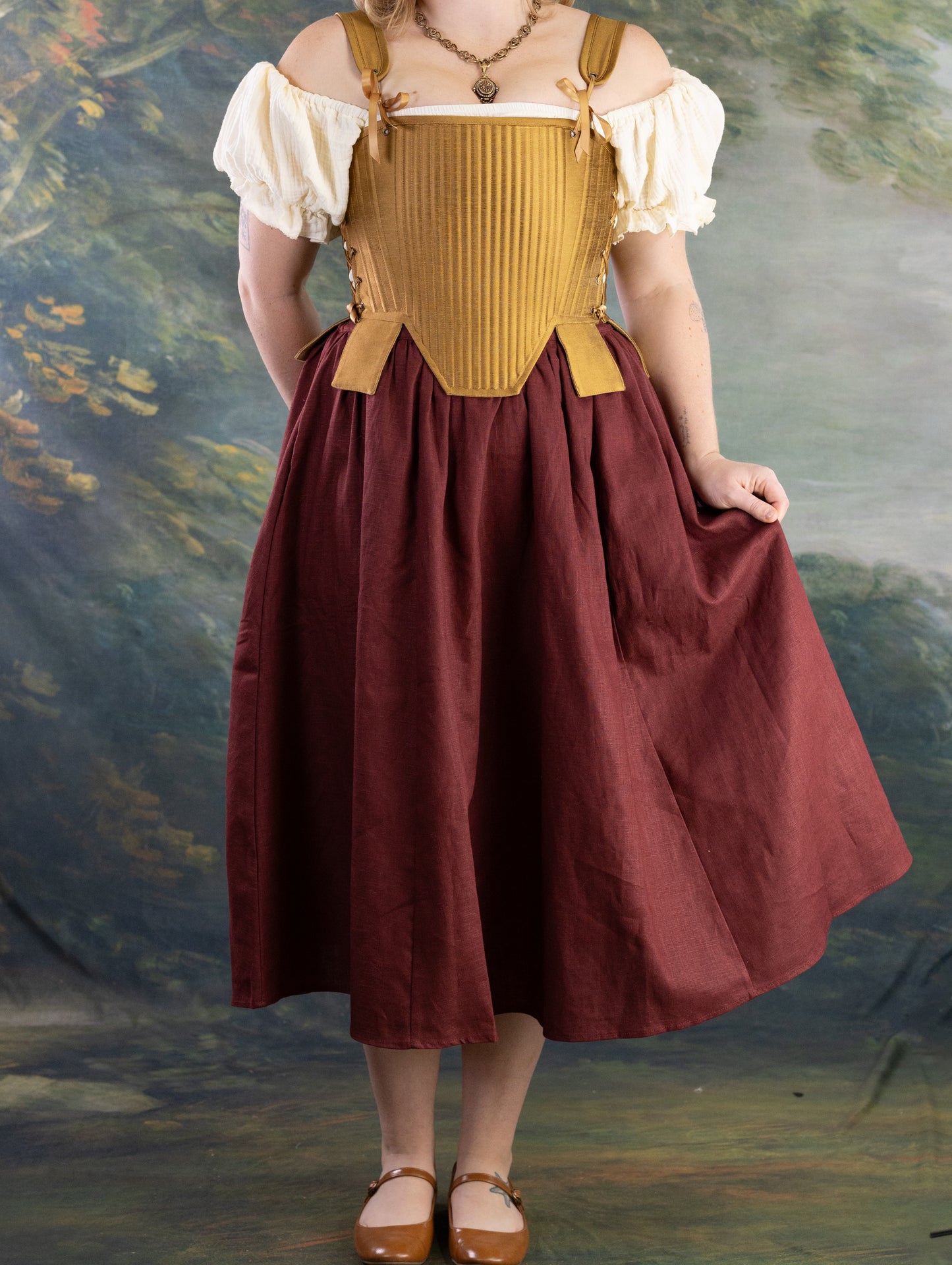 Woman wearing Gold Tabbed Tudor Stays over vintage dress with adjustable straps, boned front, and decorative waist tabs.
