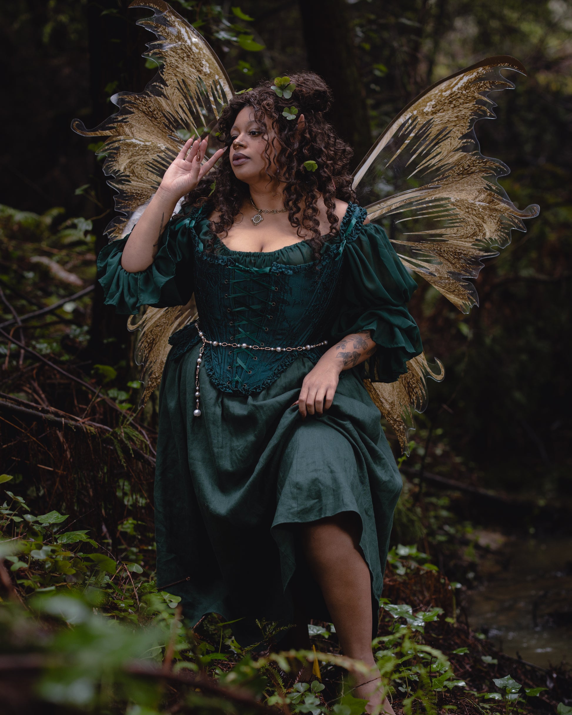 Woman dressed in Dark Green Floral Jacquard 18th Century Stays with fairy wings in a forest setting