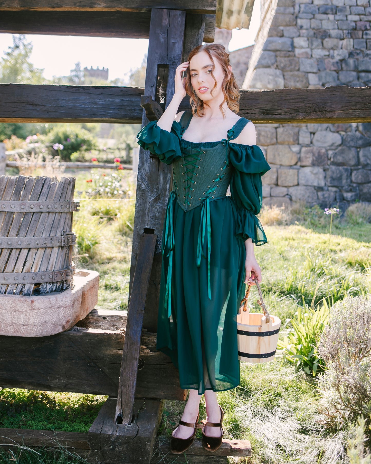 Woman outdoors wearing a forest green corset dress with bucket bag featuring Forest Green Princess Stays corset design