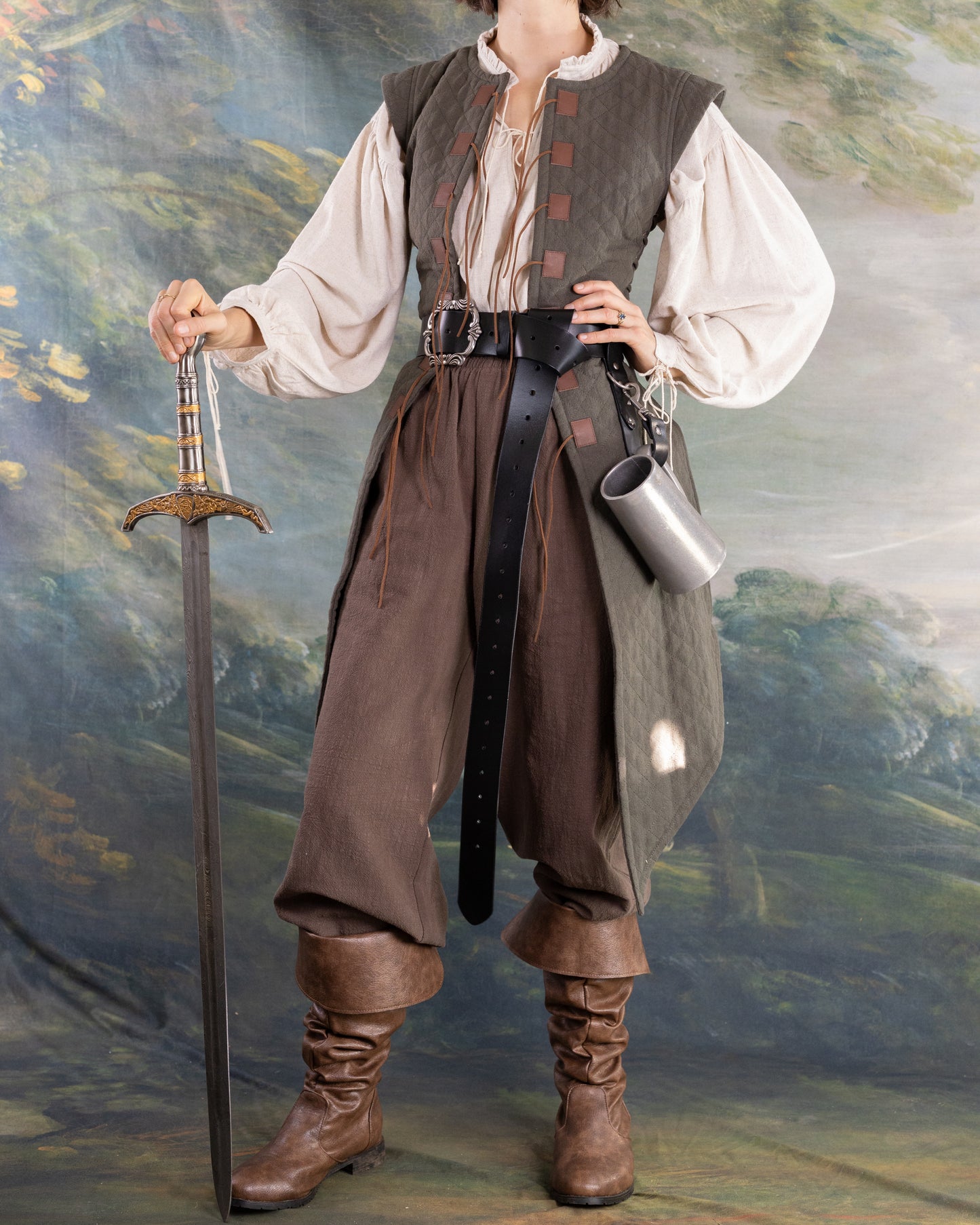 Person dressed in pirate-style clothing wearing a Leather Pirate Belt holding a sword and metal mug