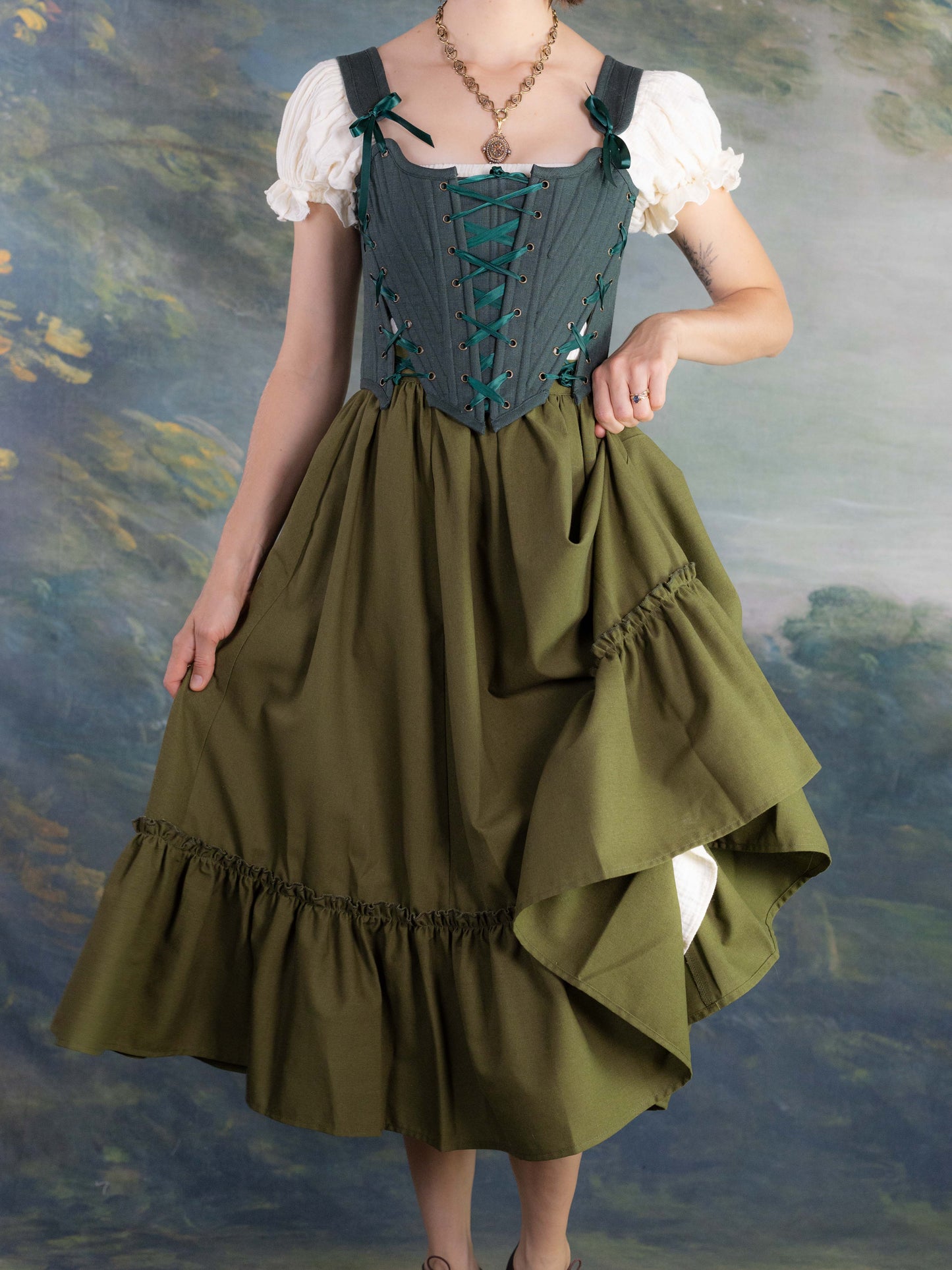 Forest Green Princess Stays corset with adjustable lacing worn over blouse and full olive skirt in vintage style setting