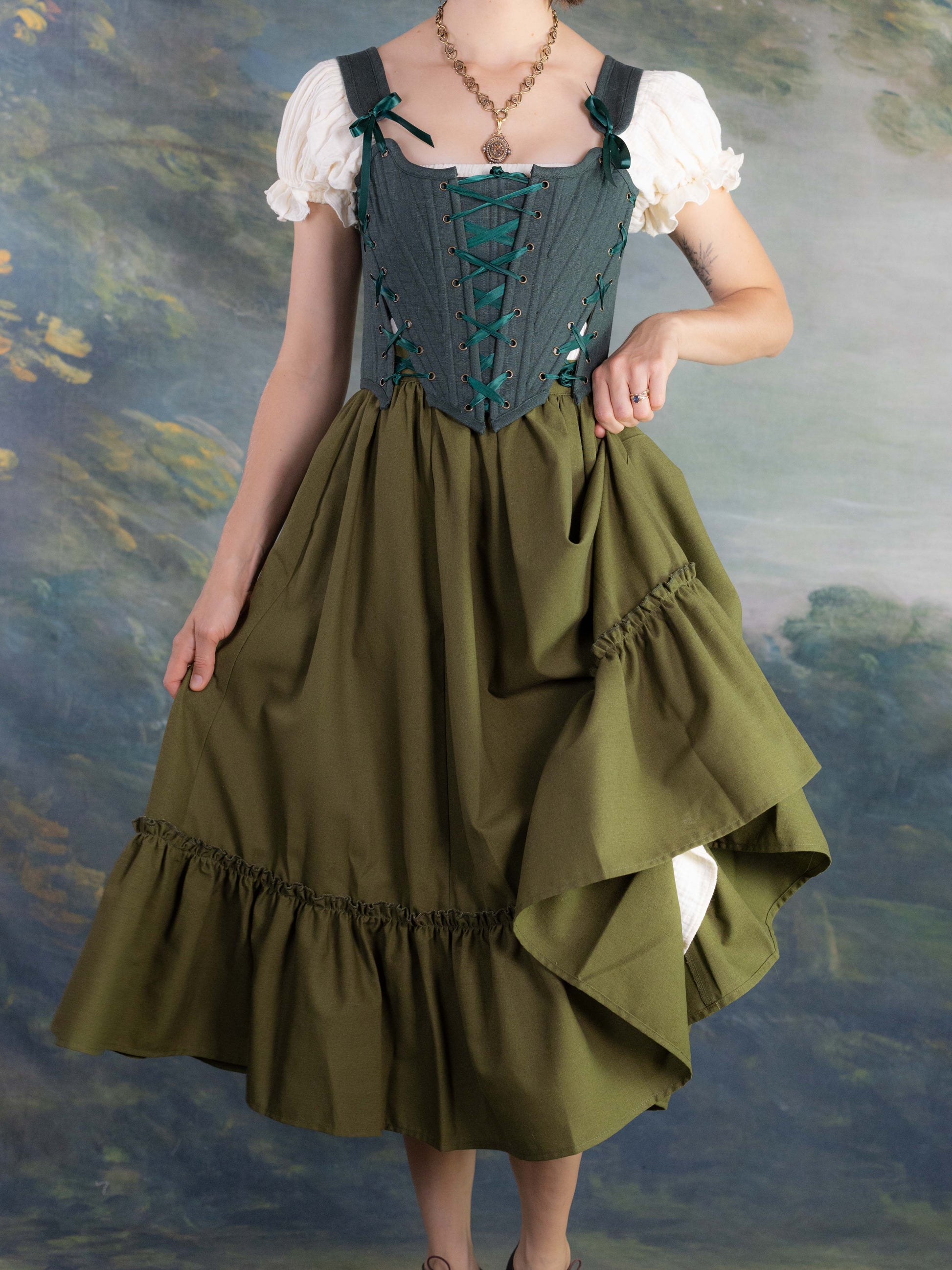 Forest Green Princess Stays corset with adjustable lacing worn over blouse and full olive skirt in vintage style setting