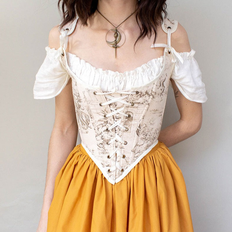 model wearing a brown renaissance corset with a golden yellow skirt