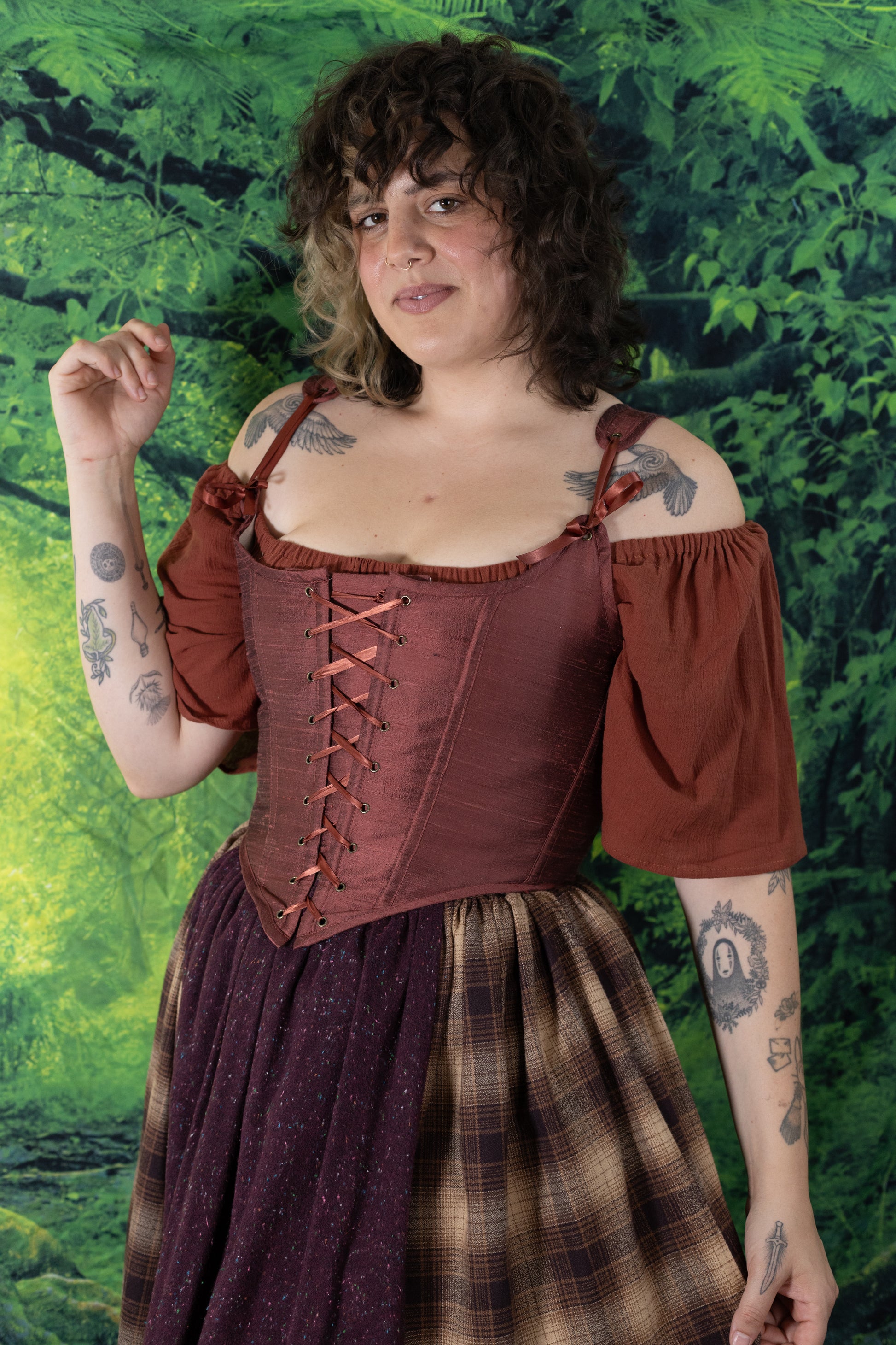 Person wearing Handmade Mary Sanderson Silk Corset in deep reddish-brown with laced front and puffed sleeves.