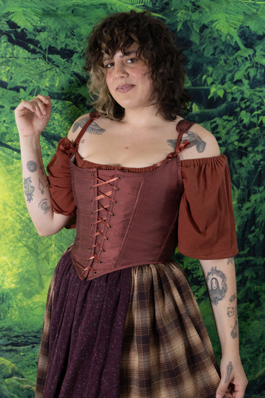 Person wearing Handmade Mary Sanderson Silk Corset in deep reddish-brown with laced front and puffed sleeves.