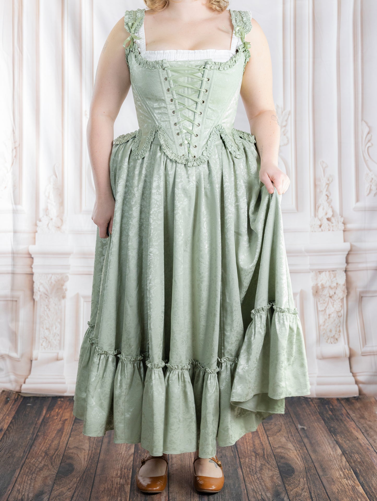 Woman wearing a vintage-style Mint Floral Ruffle Skirt with subtle floral patterns and ruffled hem standing indoors