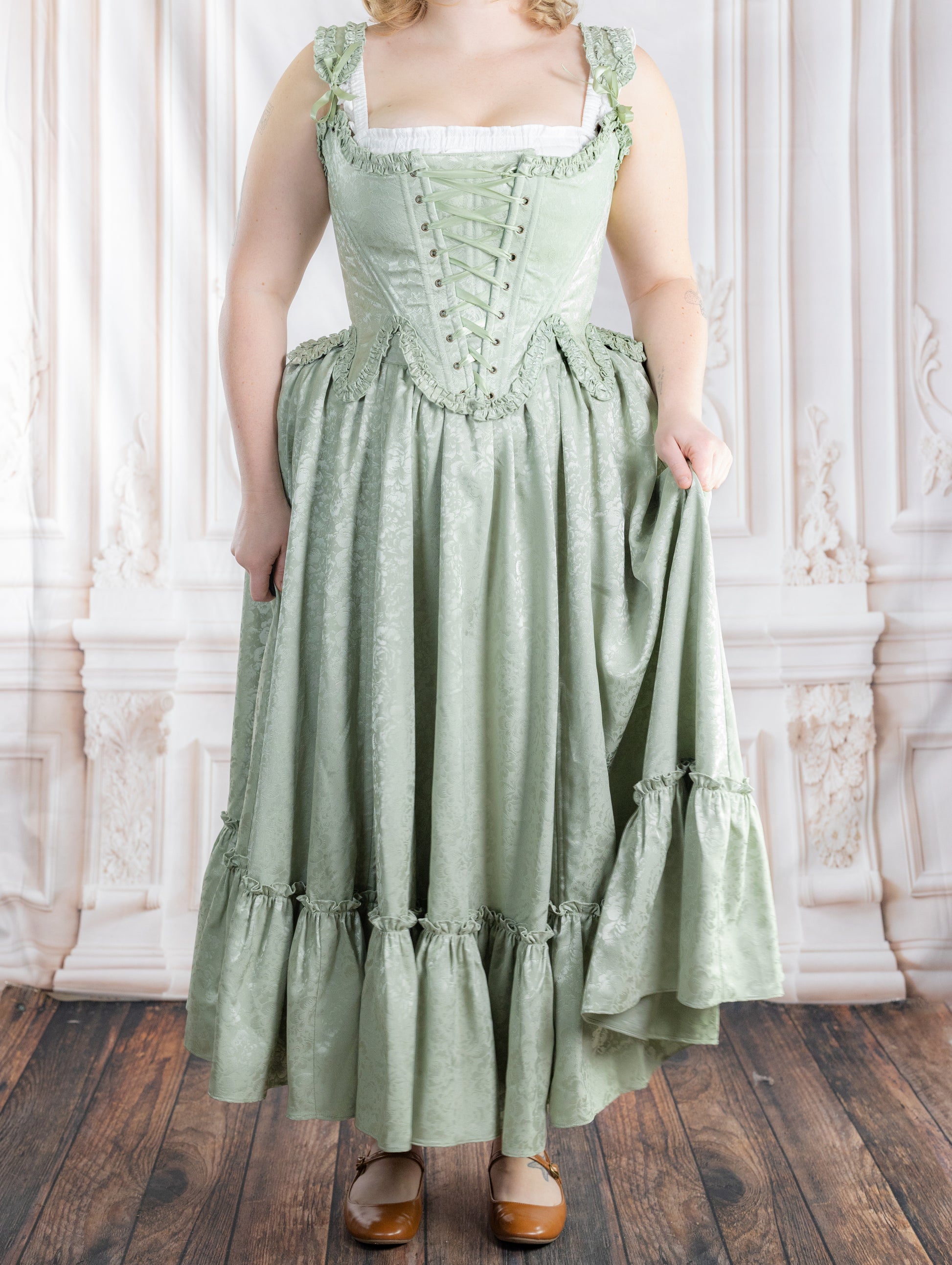 Woman wearing a vintage-style Mint Floral Ruffle Skirt with subtle floral patterns and ruffled hem standing indoors