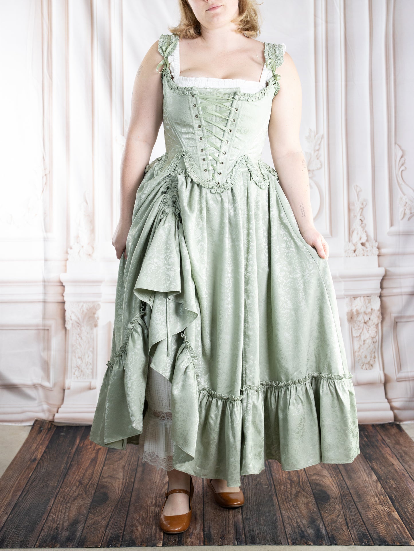 Woman wearing a pale mint green dress with lace-up bodice and full skirt featuring subtle floral pattern Mint Floral Ruffle Skirt