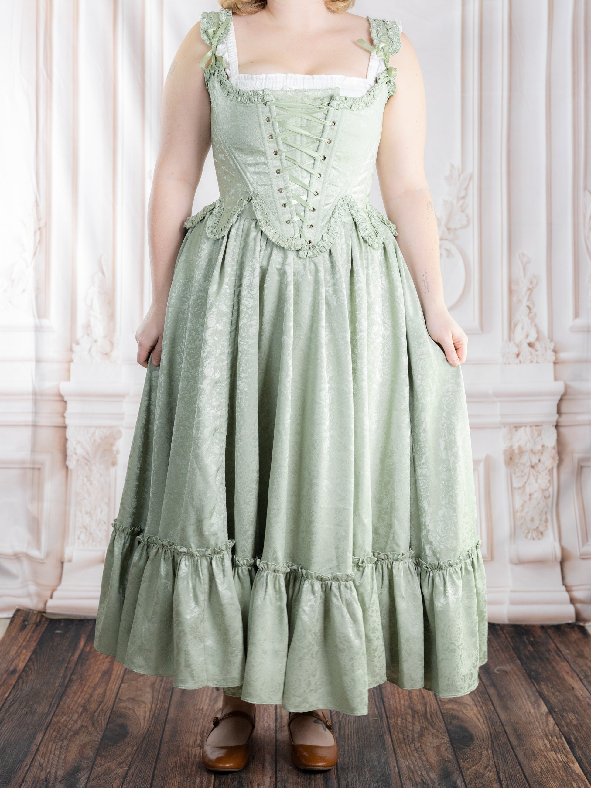 Woman wearing a mint green vintage style dress featuring the Mint Floral Ruffle Skirt with subtle floral pattern.