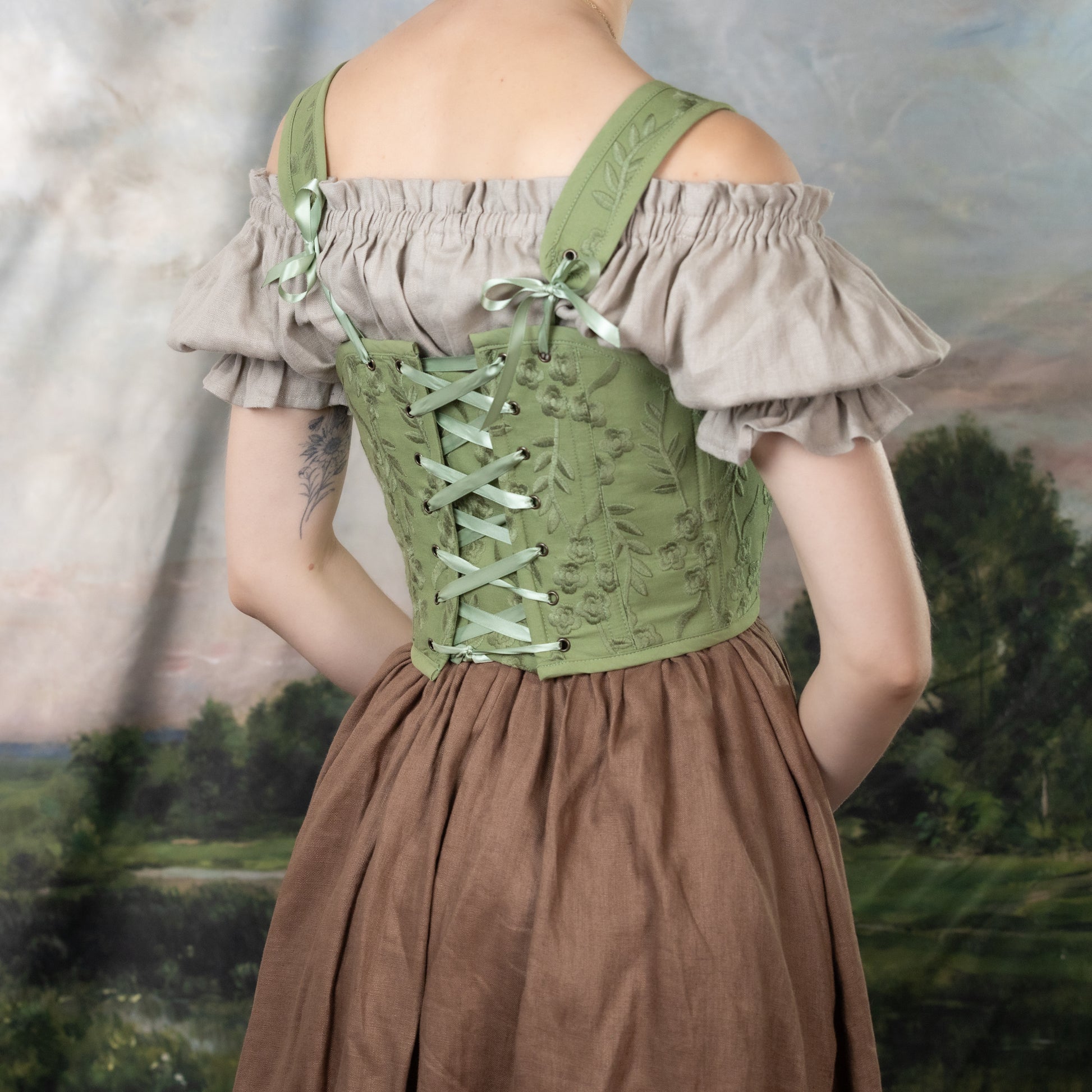 Moss Green Embroidered Floral Corset Top with ruffled off-shoulder sleeves, lace-up back, and delicate floral embroidery in Renaissance style