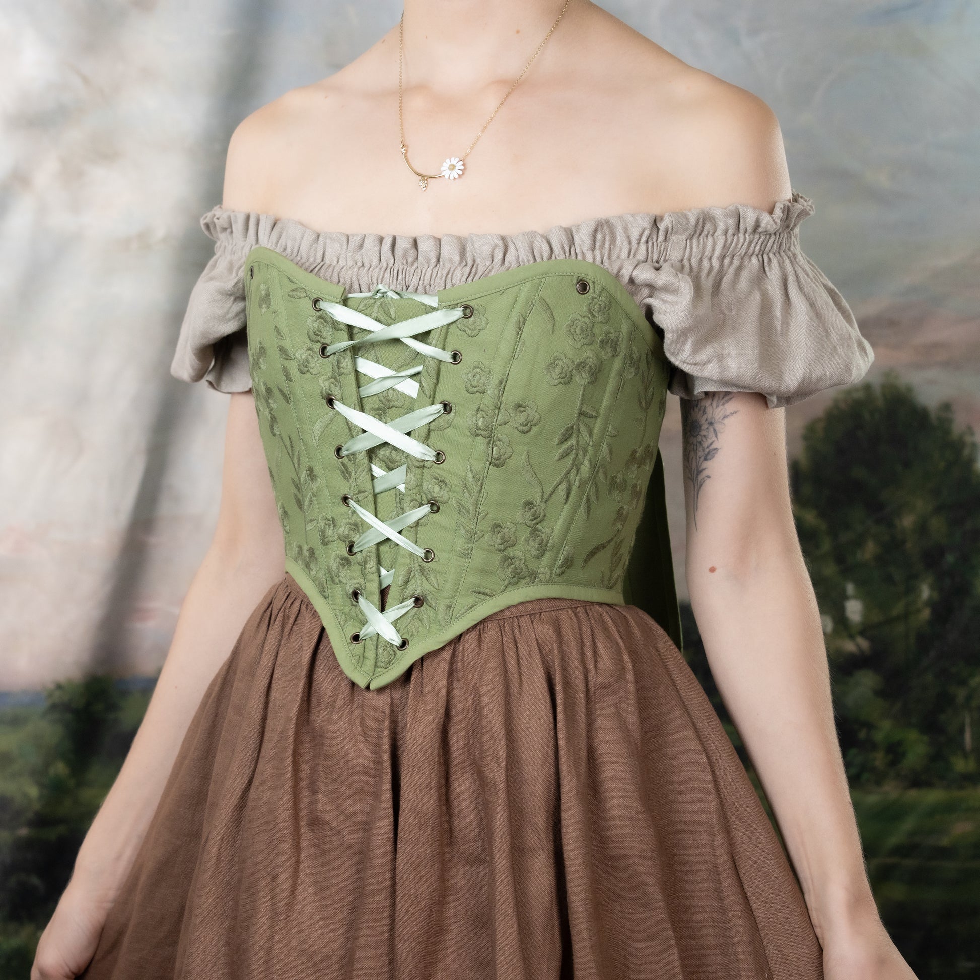 Moss Green Embroidered Floral Corset Top with off-shoulder design, lace-up front, and delicate floral embroidery on sage fabric