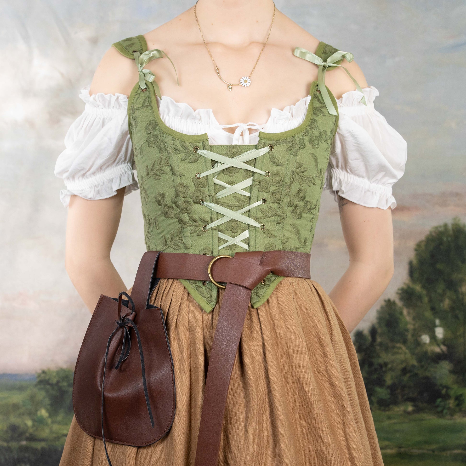 Woman wearing a Handmade Moss Green Embroidered Floral Corset over a white blouse with a brown belt and pouch.