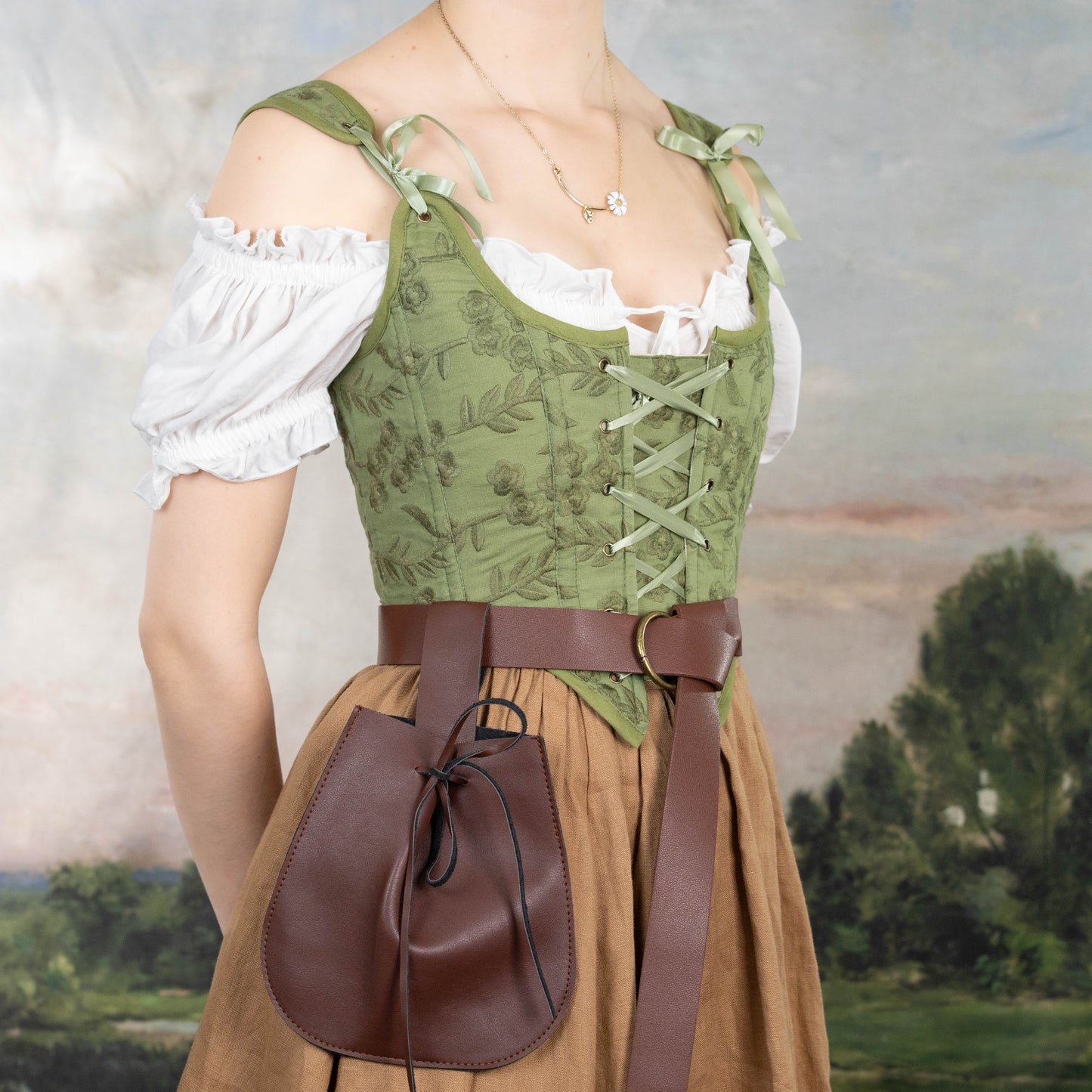 Woman wearing a Handmade Moss Green Embroidered Floral Corset over a white blouse with brown skirt and leather belt pouch