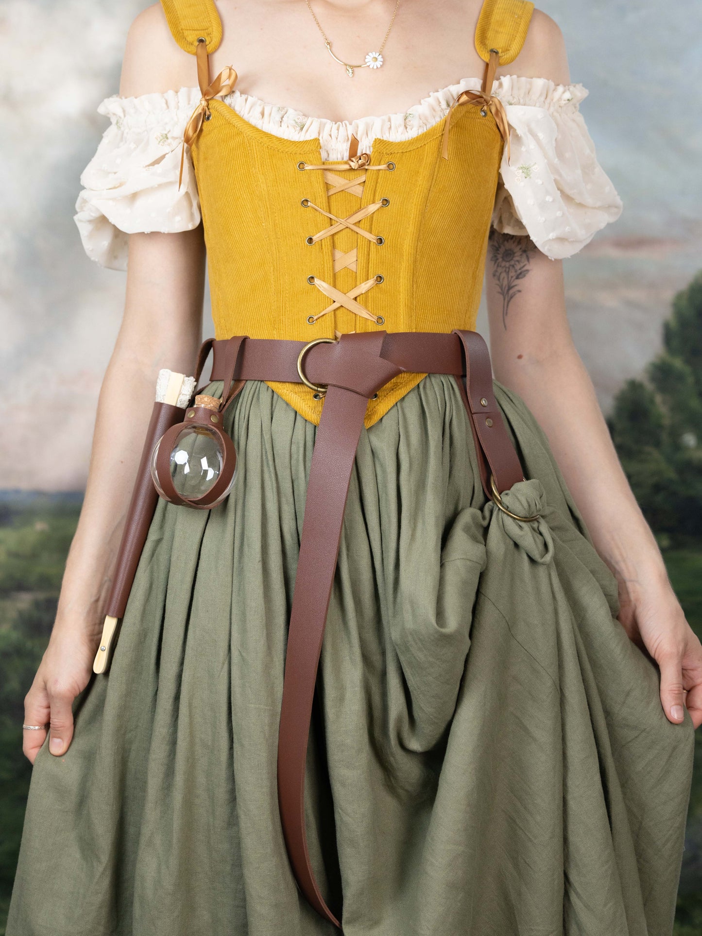 Woman wearing a Handmade Mustard Corduroy Renaissance Corset with off-shoulder blouse and long green skirt outdoors