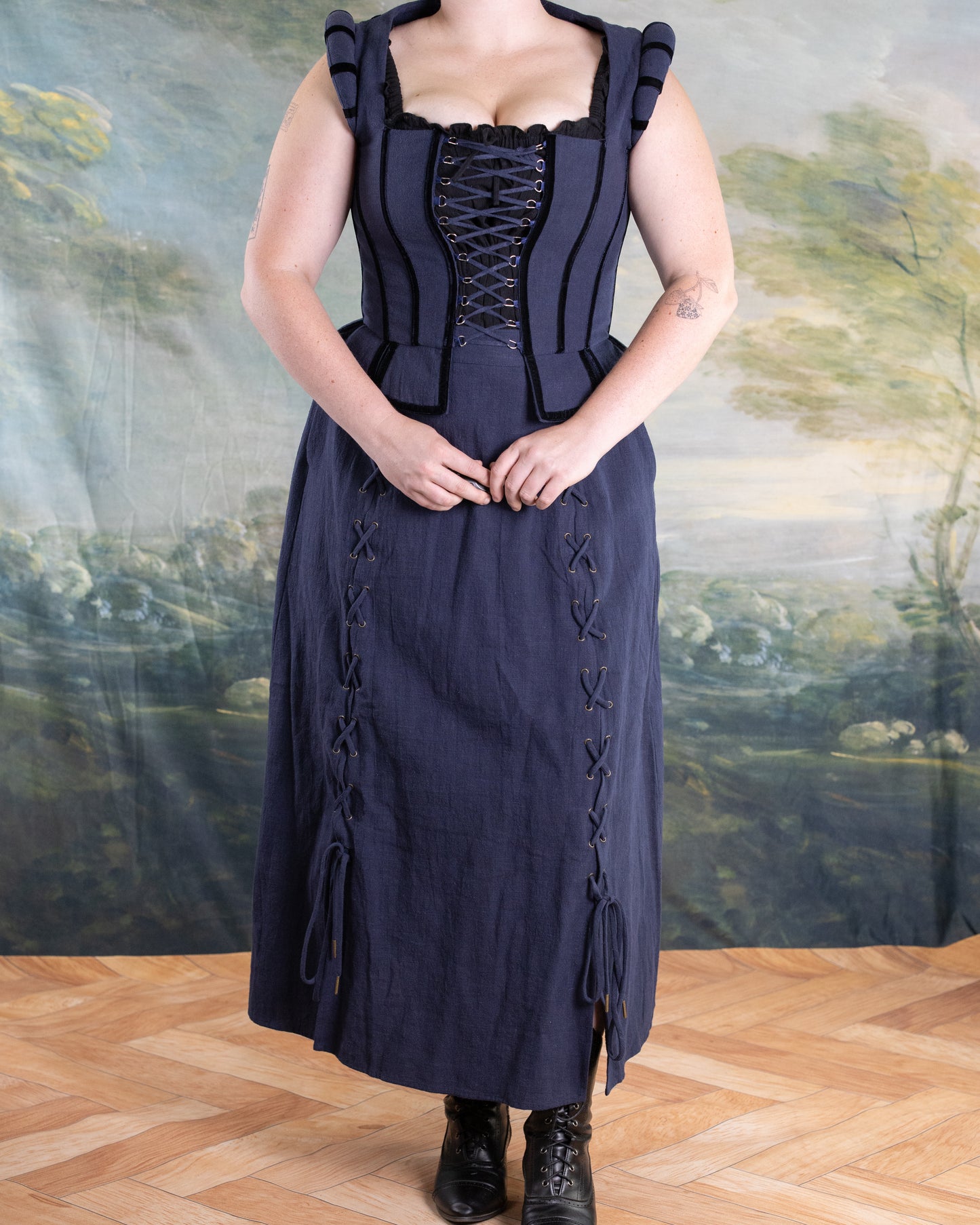 Woman wearing Navy Tavern Bodice with D-ring lace-up and matching navy skirt styled for pirate cosplay indoors