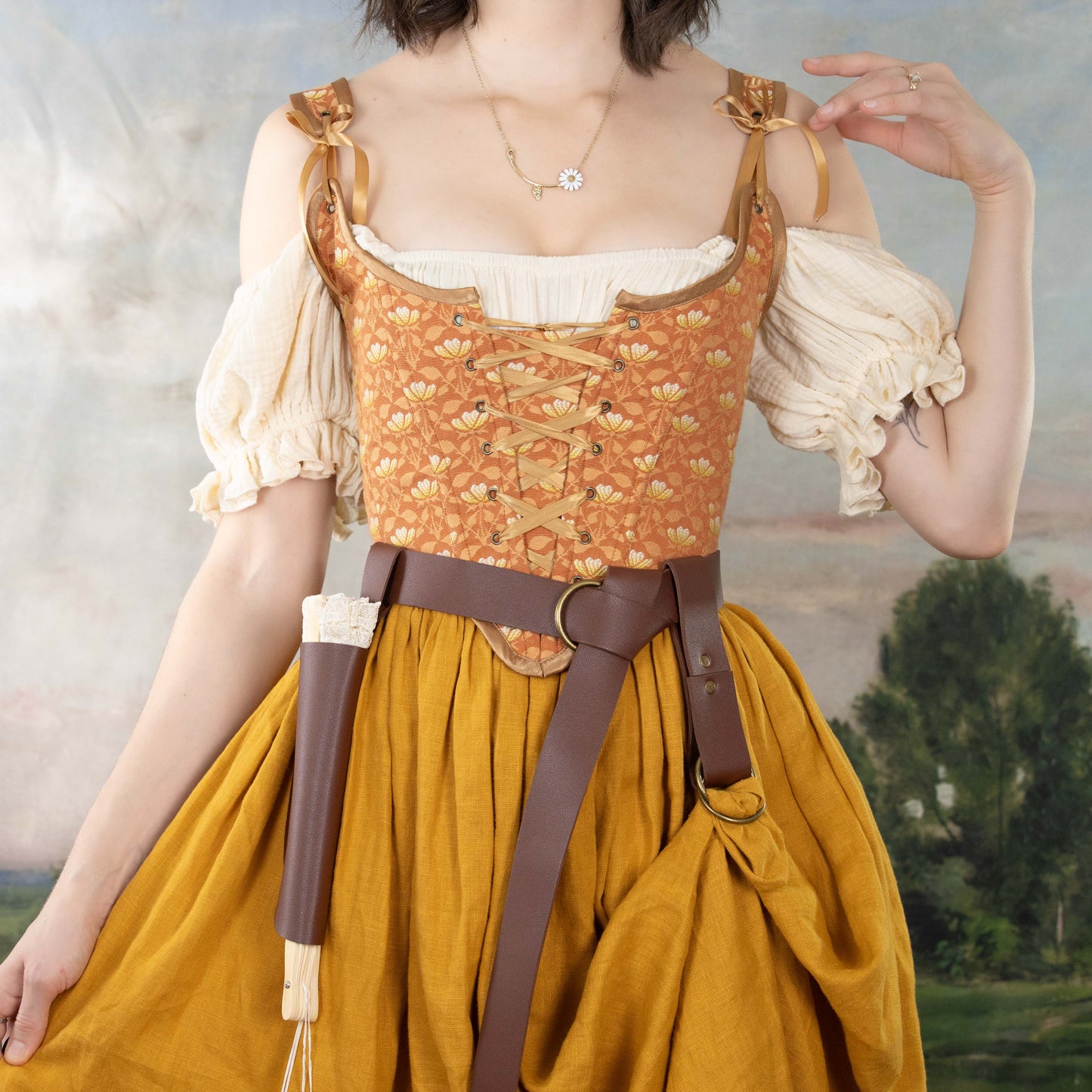 Woman wearing a Handmade Orange Floral Jacquard Corset over a cream blouse and mustard skirt with accessories